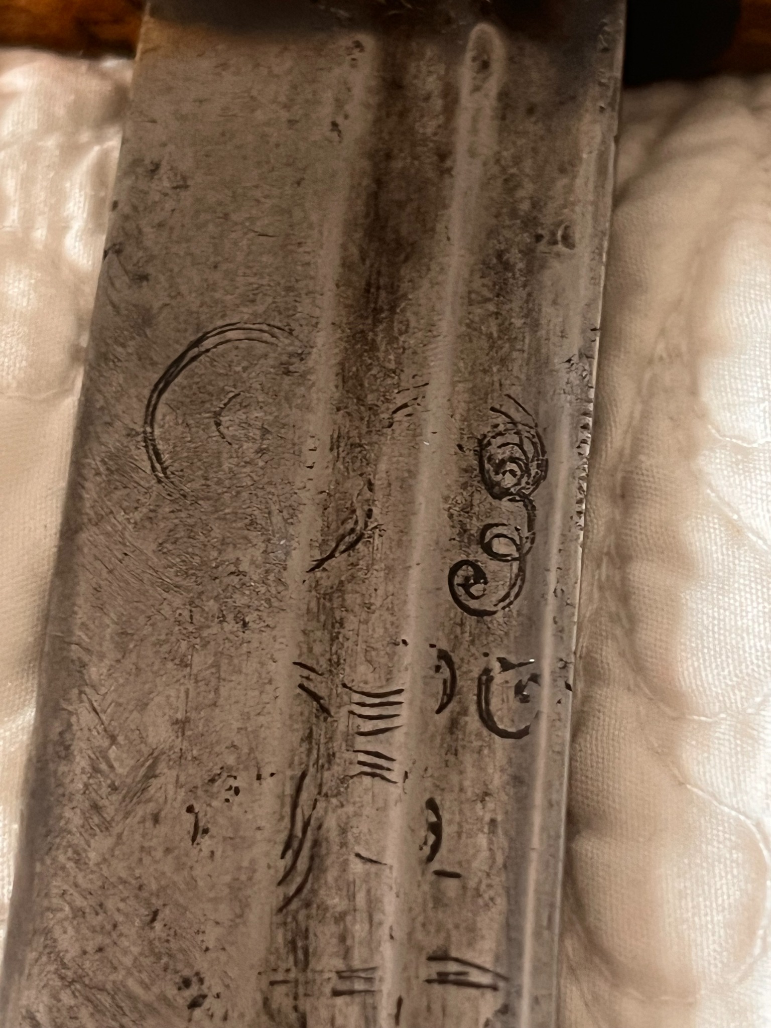 Macro view of dark deposits retained inside recessed blade engraving