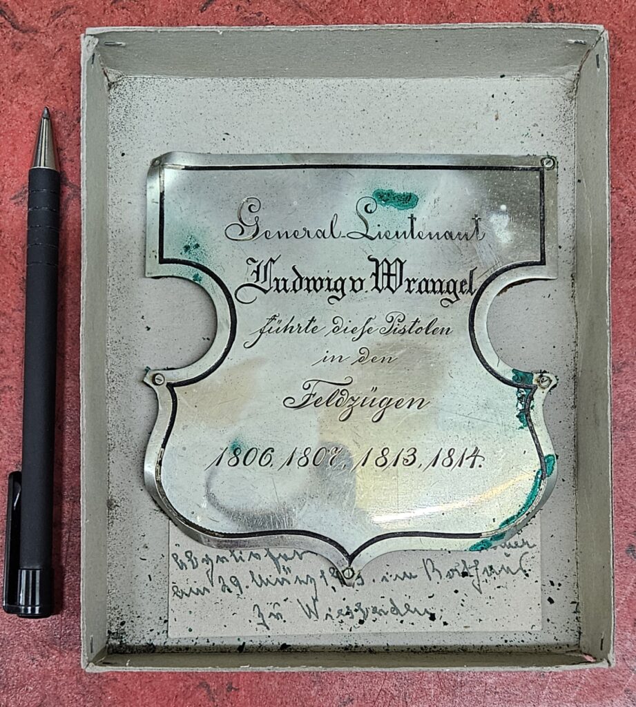 Archival metal label describing pistols carried by Lieutenant General Ludwig von Wrangel in four campaigns